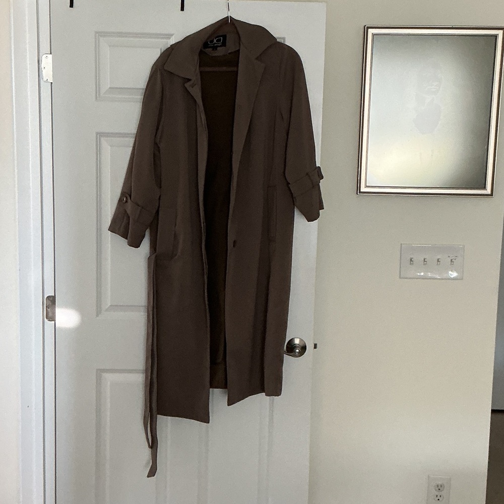 Woman’s tan raincoat with a zip out lining and a detachable hood.